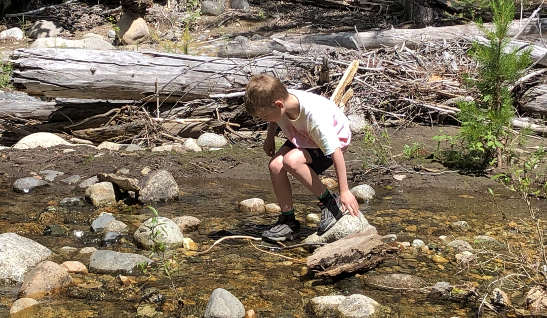 son playing in the river